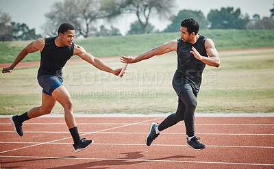Buy stock photo Full length shot of a handsome young male athlete grabbing a baton from his teammate during a relay race