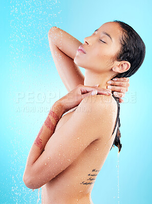 Buy stock photo Shot of a young woman enjoying a shower against a blue background