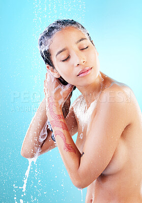 Buy stock photo Shot of a woman washing her hair against a blue background