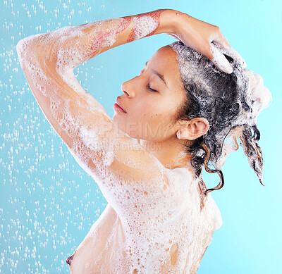 Buy stock photo Shot of a woman washing her hair against a blue background