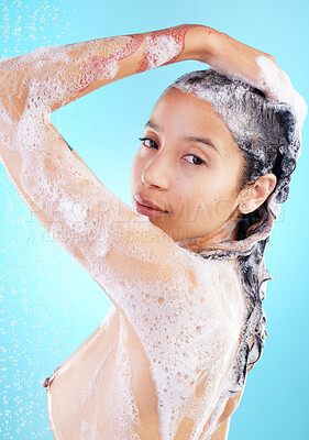 Buy stock photo Shot of a woman washing her hair against a blue background