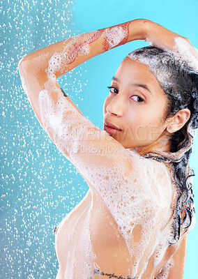 Buy stock photo Shot of a woman washing her hair against a blue background