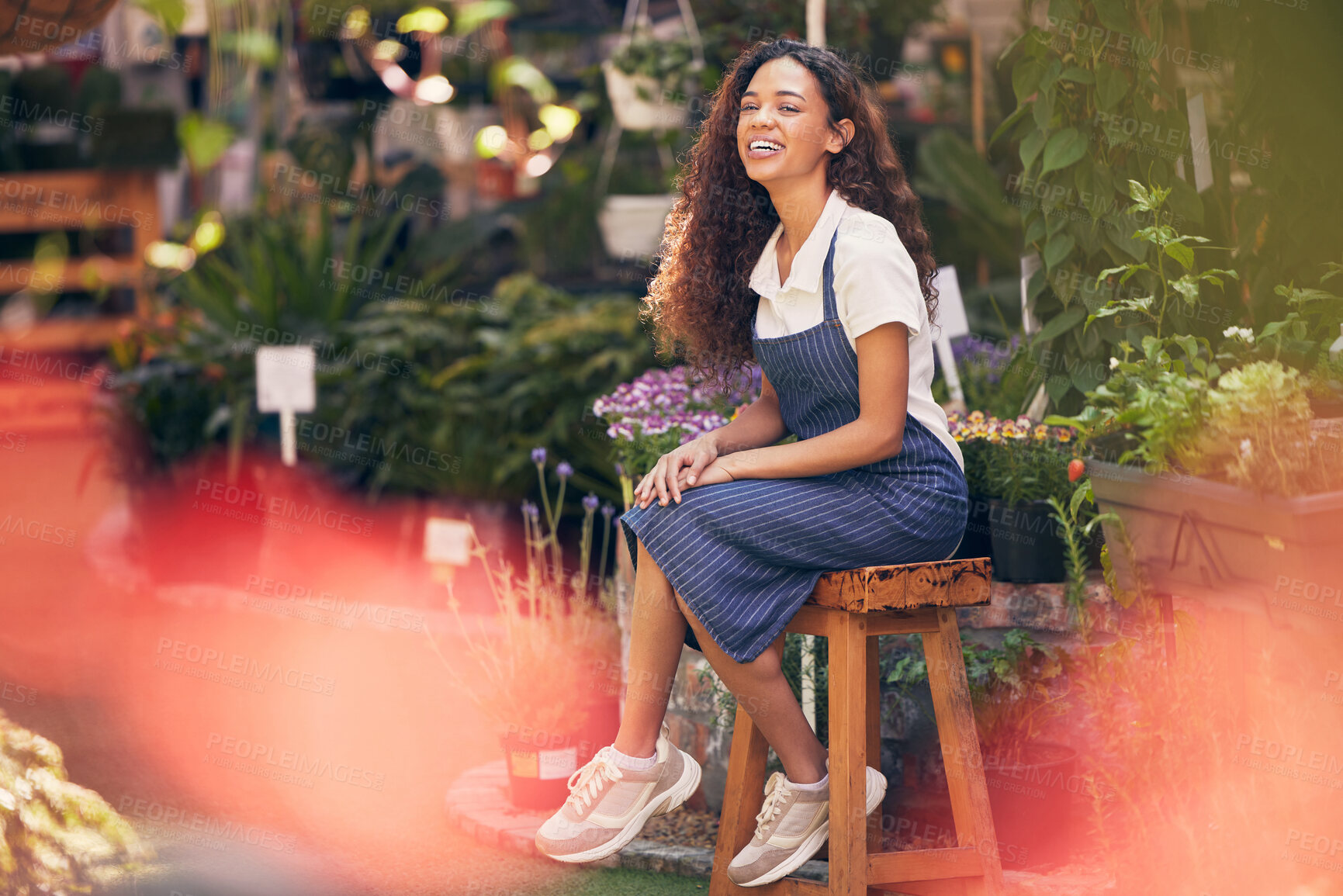 Buy stock photo Shot of a beautiful young florist sitting in her garden