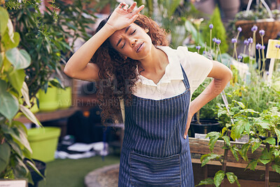 Buy stock photo Shot of a young florist experiencing a headache at work