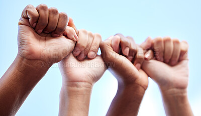 Buy stock photo Shot of an unrecognisable group of women raising their hands in strength outside