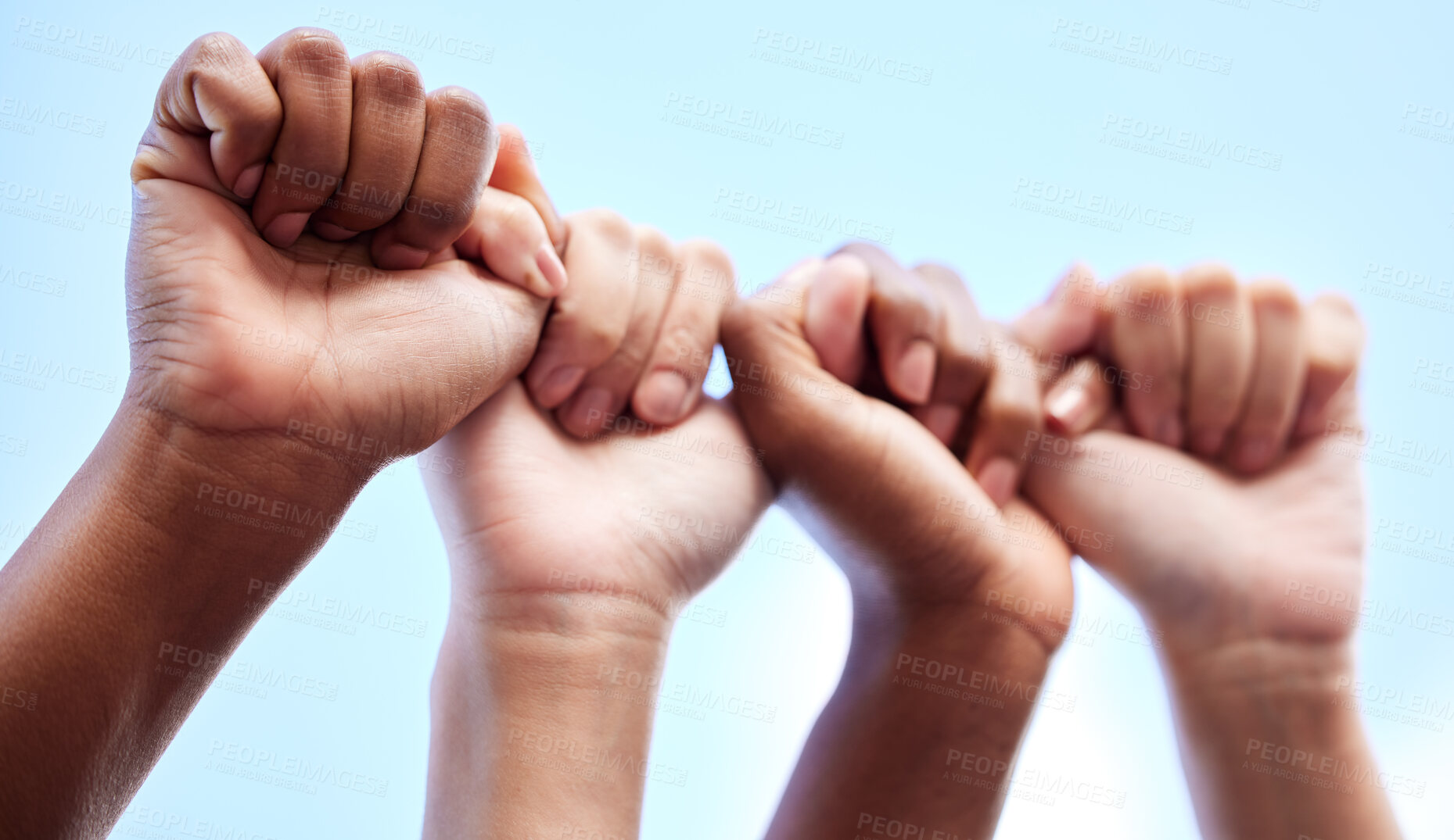 Buy stock photo Shot of an unrecognisable group of women raising their hands in strength outside