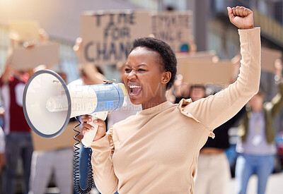 Buy stock photo Shot of a young woman shouting through a loudhailer at a protest
