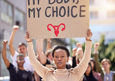 Buy stock photo Shot of a young woman at a rally holding a placard