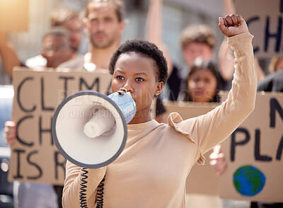 Buy stock photo Shot of a young woman speaking through a megaphone at a protest