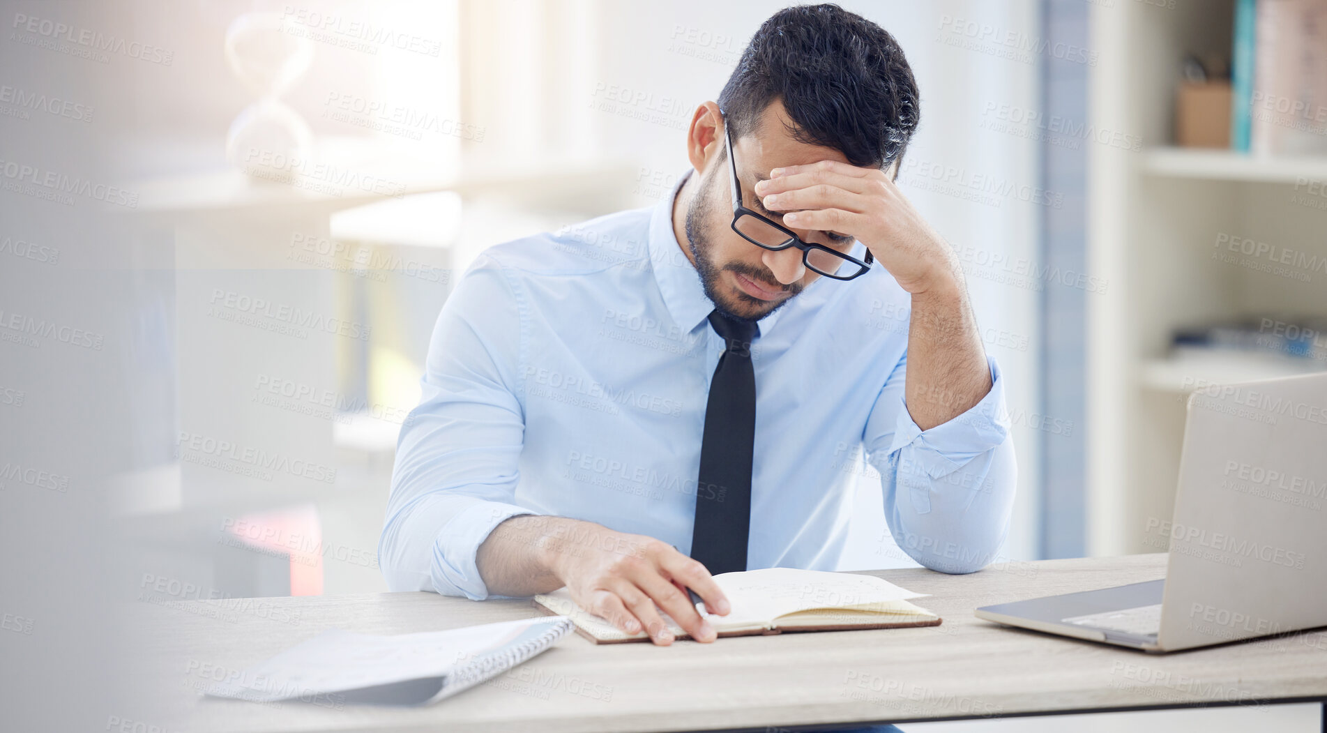 Buy stock photo Headache, man and notebook in office for deadline, debt and overworked in workplace. Male lawyer, frustrated and laptop at desk with anxiety, burnout and tired at desk from workload, pressure or work