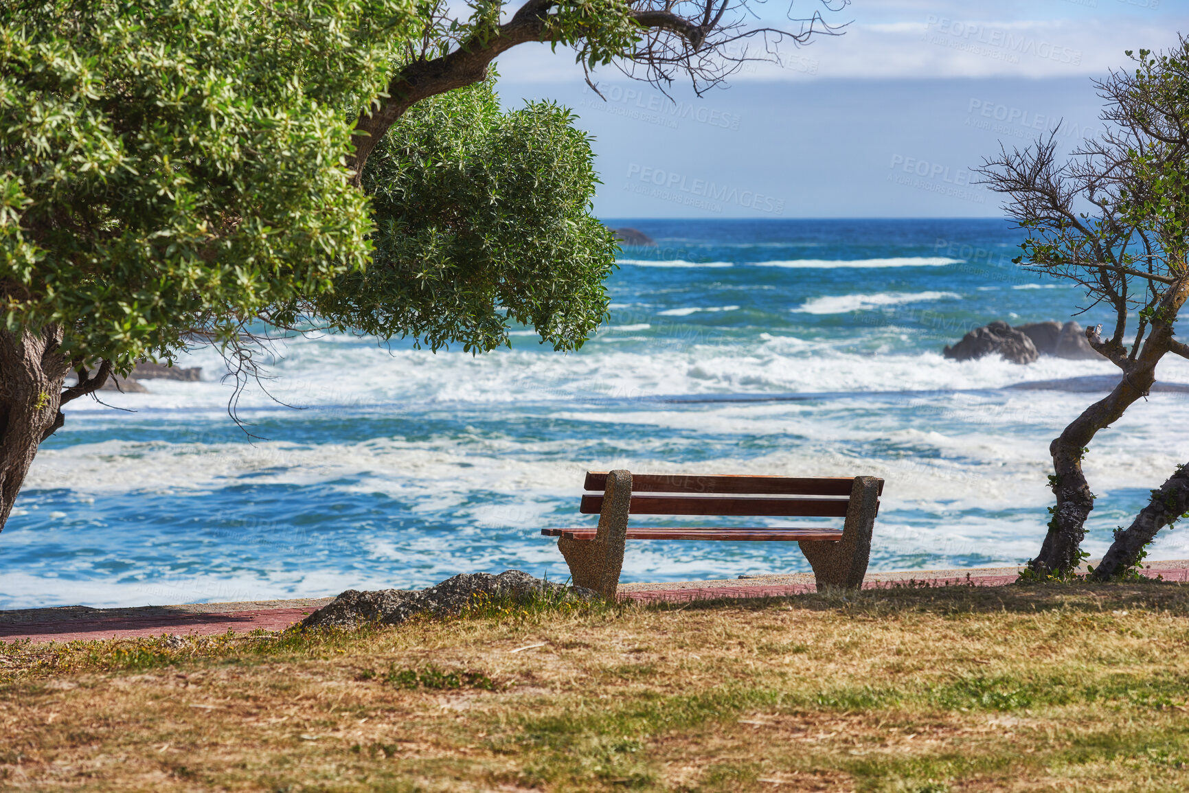 Buy stock photo Relaxing bench with sea or ocean view to enjoy calm, peaceful or zen beach with waves washing on shore in remote area. Scenic seating, blue sky and copy space in a coastal park on the promenade