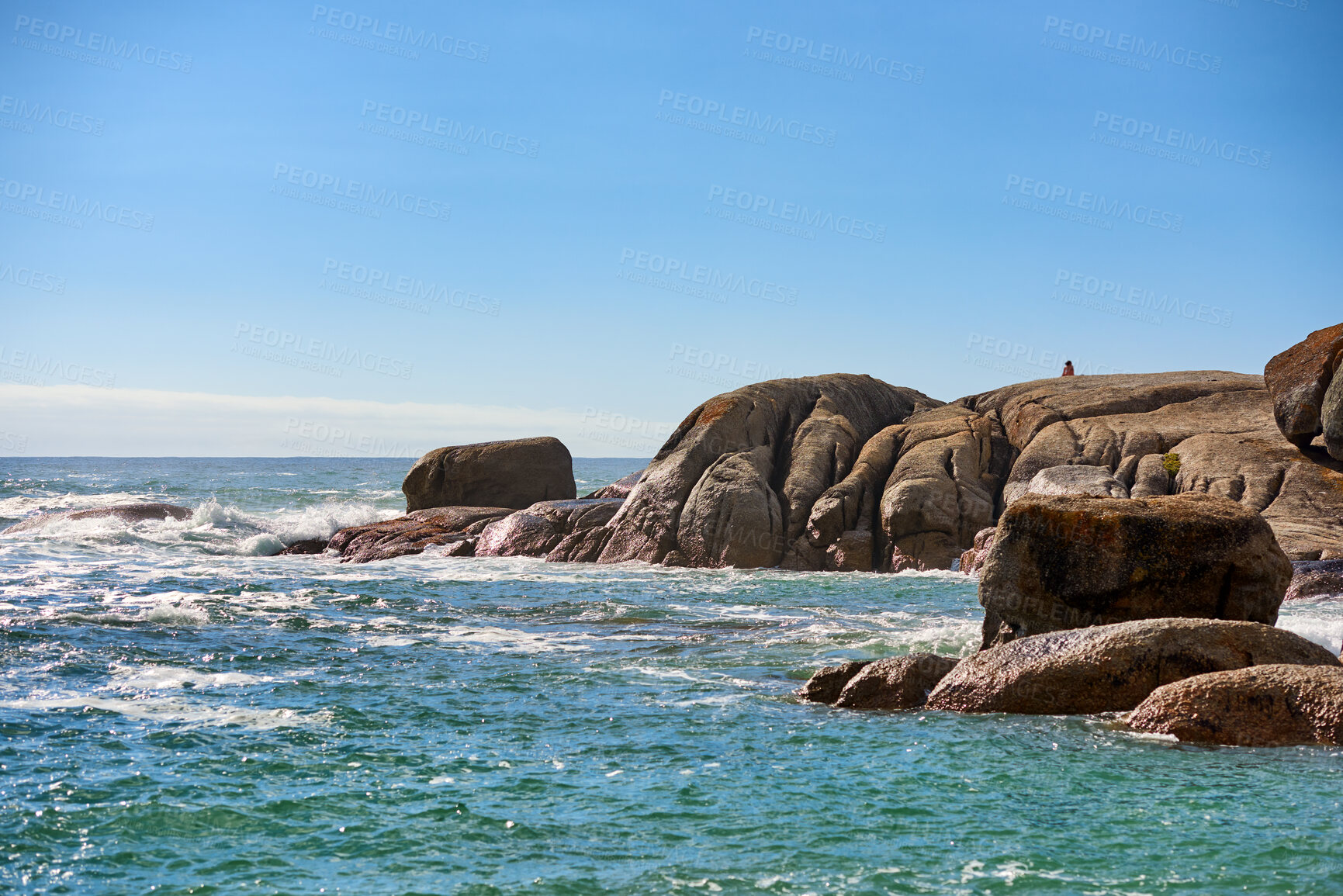 Buy stock photo Big boulders, rocks and stones at the beach, sea and ocean against a clear blue sky background with copy space. Calm, majestic and scenic landscape view across the horizon and rocky coast in summer