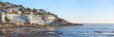 Buy stock photo Panorama of city on a mountain near the sea with a clear blue sky for copy space background. Scenic landscape of a coastal town on a hill with a quiet and calm ocean scene near Clifton, South Africa