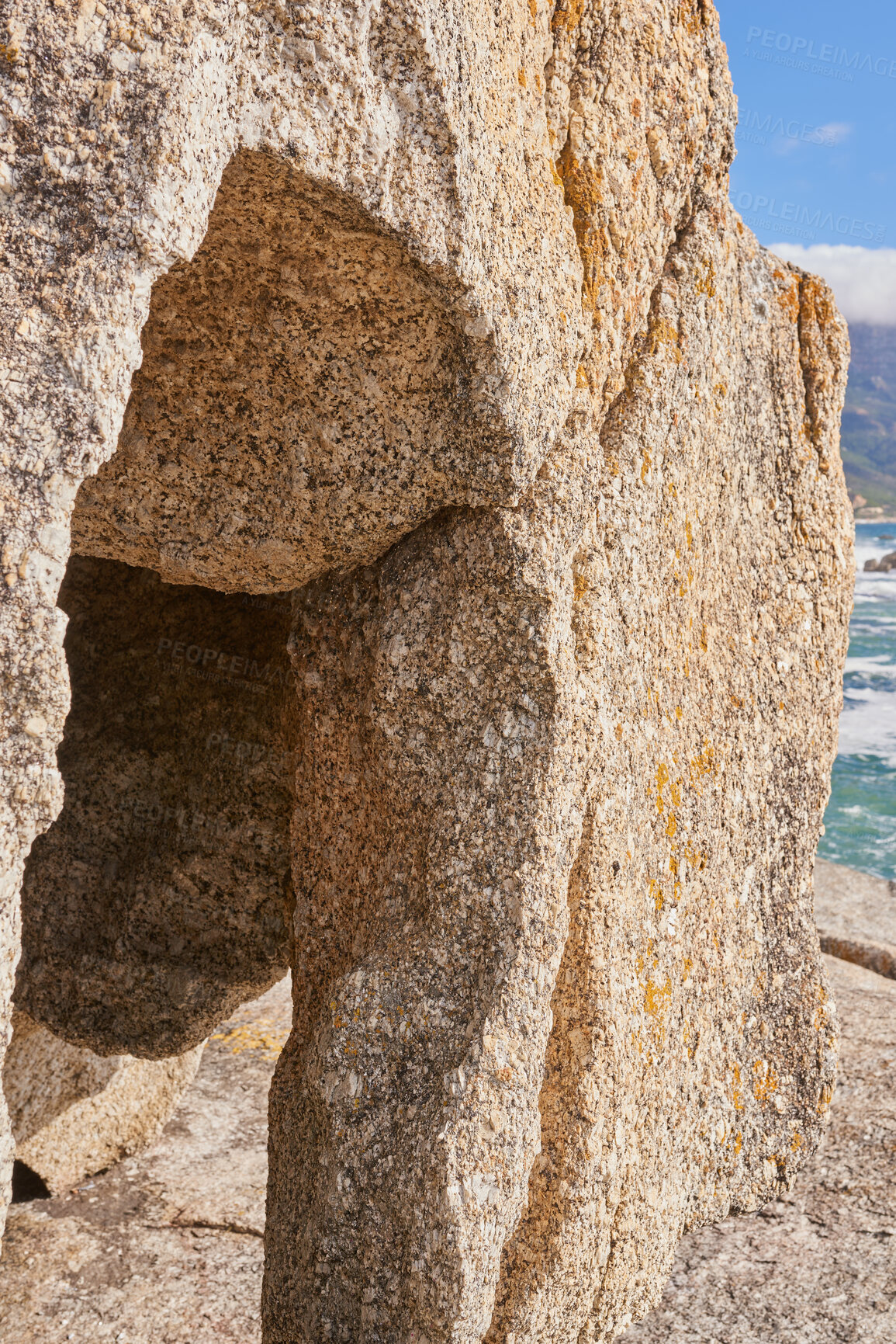 Buy stock photo Closeup of a crevice or gully formed by the erosion of sea water. Large boulder or sandstone on a beach with the ocean in the background. Sedimentary rock acting as wave breaker on coastal seaside