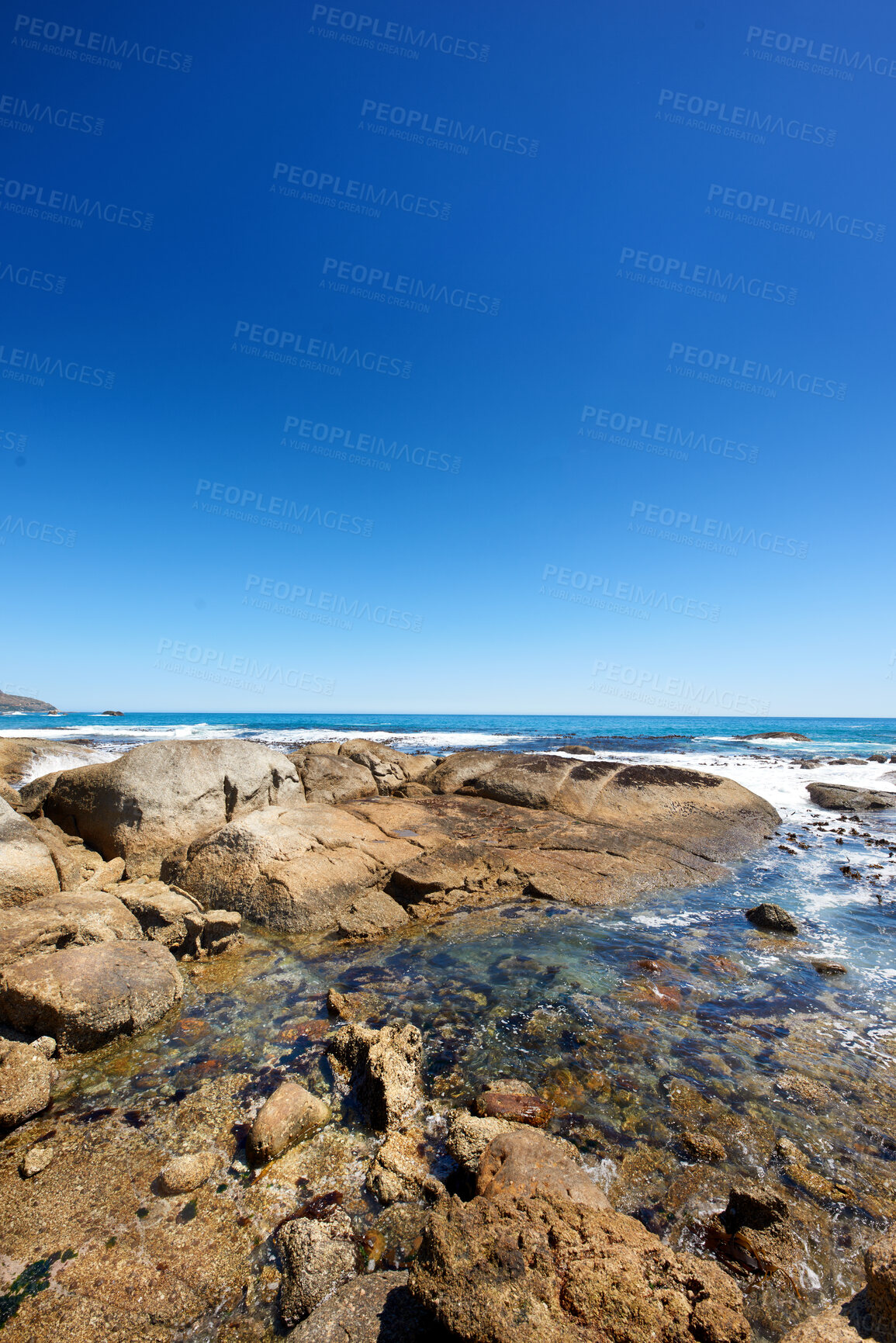 Buy stock photo Big rocks in the ocean or sea water with a blue sky background. Beautiful landscape with a scenic view of the beach with boulders on a summer day. Relaxing scenery of the seaside or nature