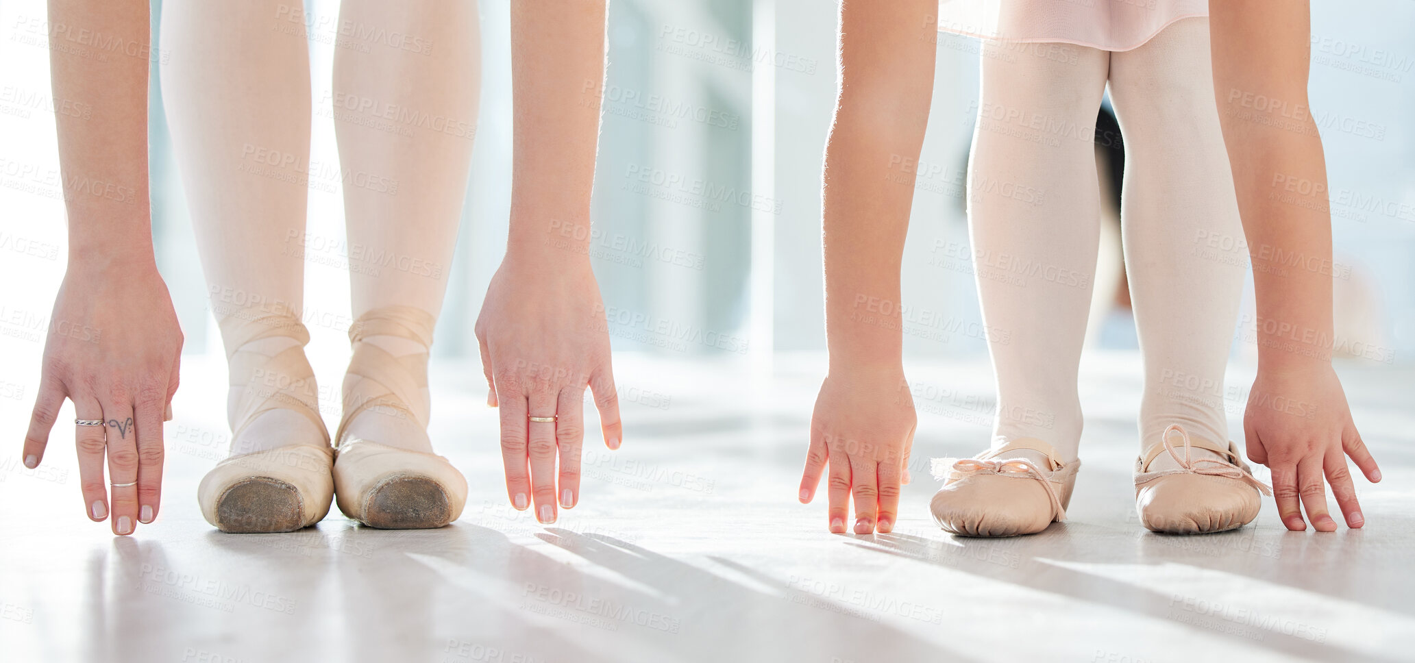 Buy stock photo Shot of two unrecognizable ballerinas stretching in a dance studio