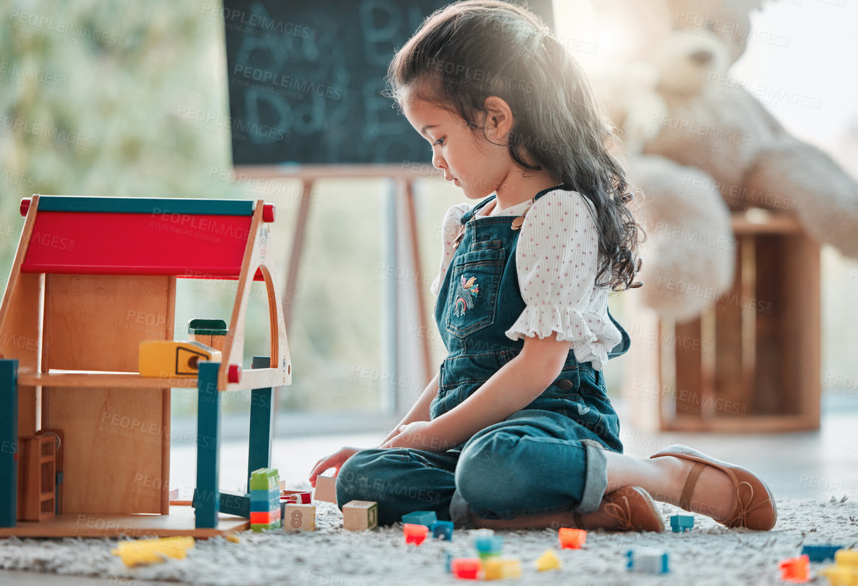 Buy stock photo Girl, tiny house and child play in home, games and fantasy for brain development in lounge. Female person, toys and blocks on floor for entertainment, growth and toddler for education or learning