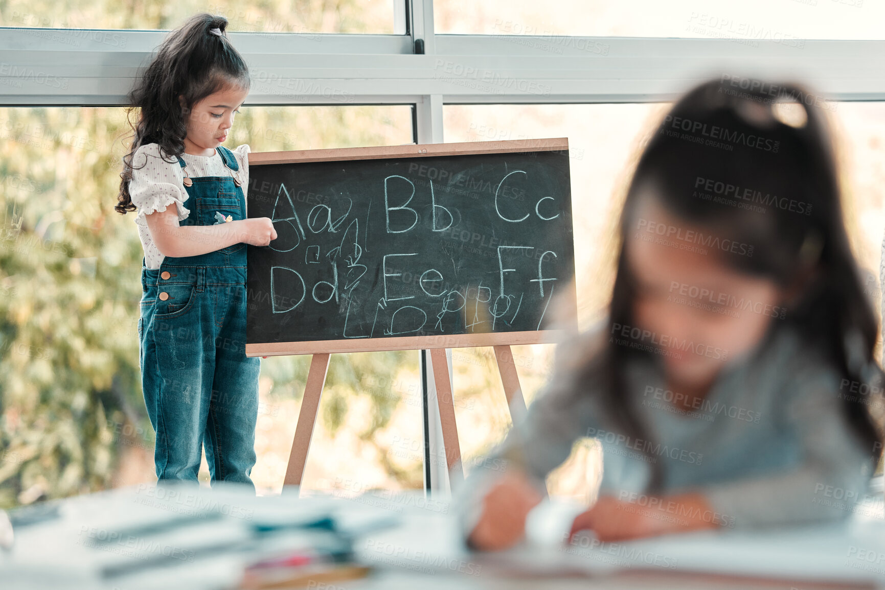 Buy stock photo Little girl, blackboard and writing alphabet in classroom for education, literature or knowledge. ABC, childcare development and kids with foundation for literacy, grammar or language in kindergarten