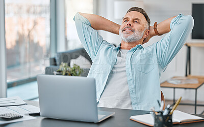 Buy stock photo Shot of a mature businessman sitting alone in his home office with his hands behind his head in relief