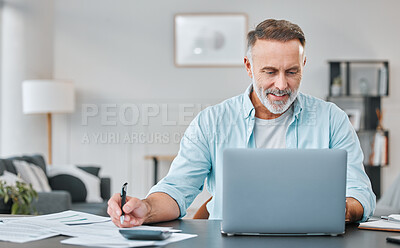 Buy stock photo Shot of a mature businessman sitting alone in his home office and using his laptop while calculating his finances