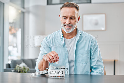 Buy stock photo Shot of a mature man sitting alone at home and putting money aside for his pension