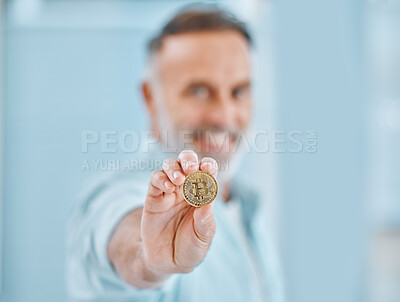 Buy stock photo Shot of an unrecognisable businessman standing alone and holding a bitcoin