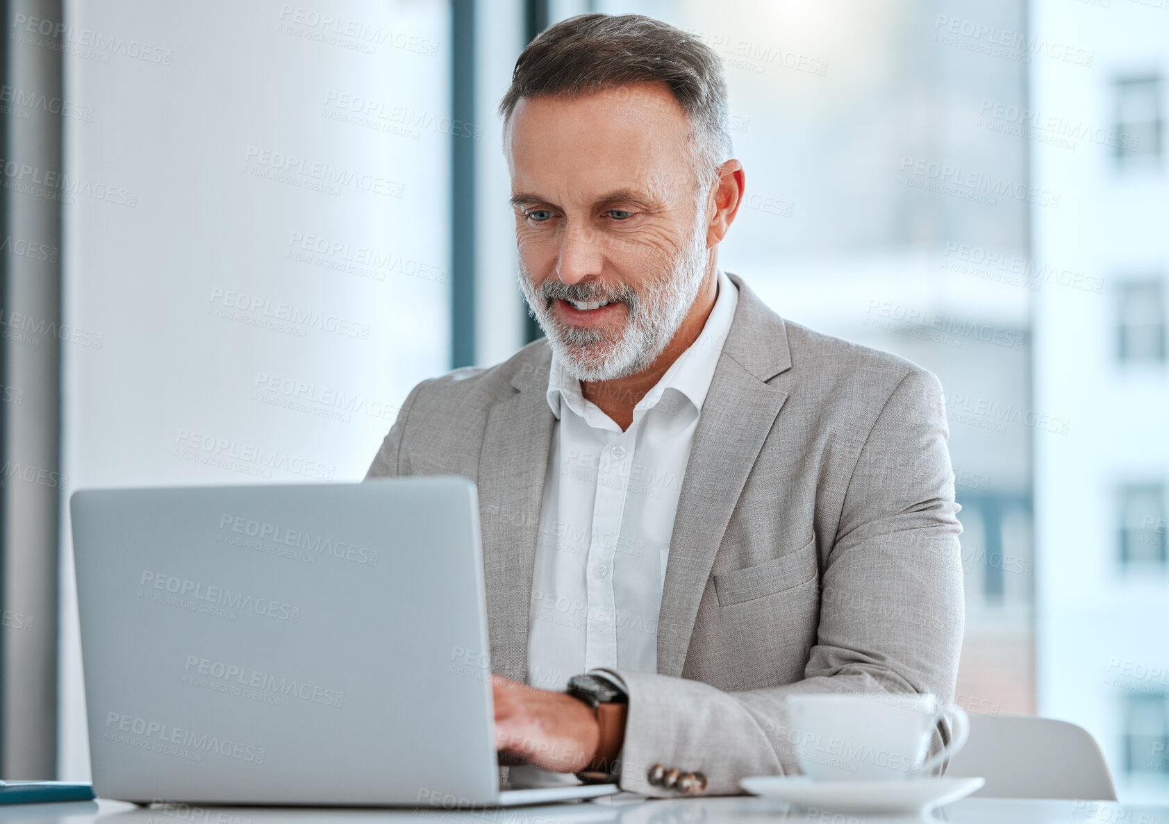 Buy stock photo Shot of a mature man using a computer at work in a office