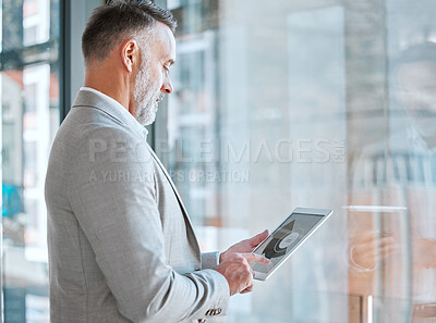 Buy stock photo Shot of a mature man using a tablet in a office
