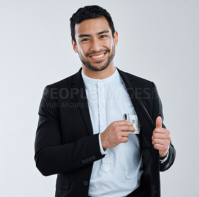 Buy stock photo Shot of a businessman slipping money into his pocket against a grey background