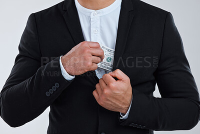 Buy stock photo Shot of a unrecognizable businessman slipping money into his pocket against a grey background