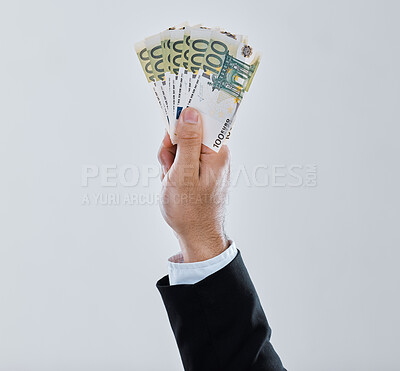 Buy stock photo Shot of a businessman stretching out his hand holding money against a grey background