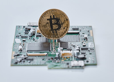 Buy stock photo Shot of a computer chip and a single bitcoin against a grey background