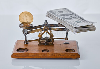 Buy stock photo Shot of a scale balancing a coin and a wad of cash against a grey background