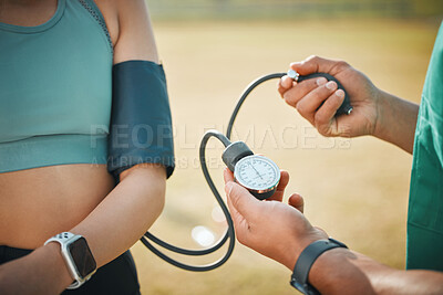 Buy stock photo Closeup shot of an unrecognisable sports paramedic checking an athlete's blood pressure