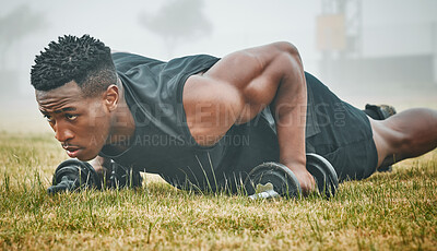 Buy stock photo Shot of a muscular young man exercising with dumbbells outdoors