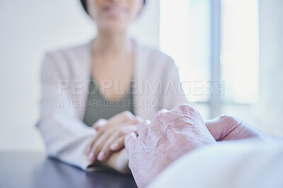Buy stock photo Shot of two businesspeople holding hands while sitting in an office