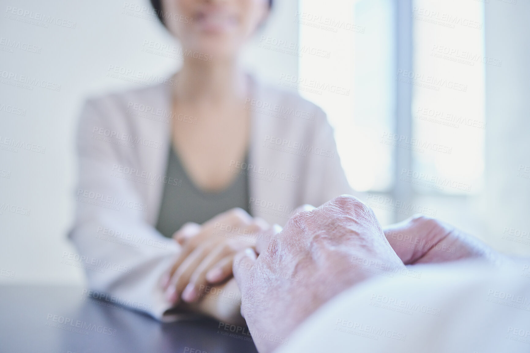 Buy stock photo Shot of two businesspeople holding hands while sitting in an office