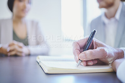 Buy stock photo Shot of a businessman writing while sitting in a meeting