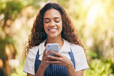 Buy stock photo Shot of a young florist using her smartphone to send a text message