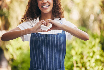 Buy stock photo Shot of a young nursery owner making a heart shape with her hand