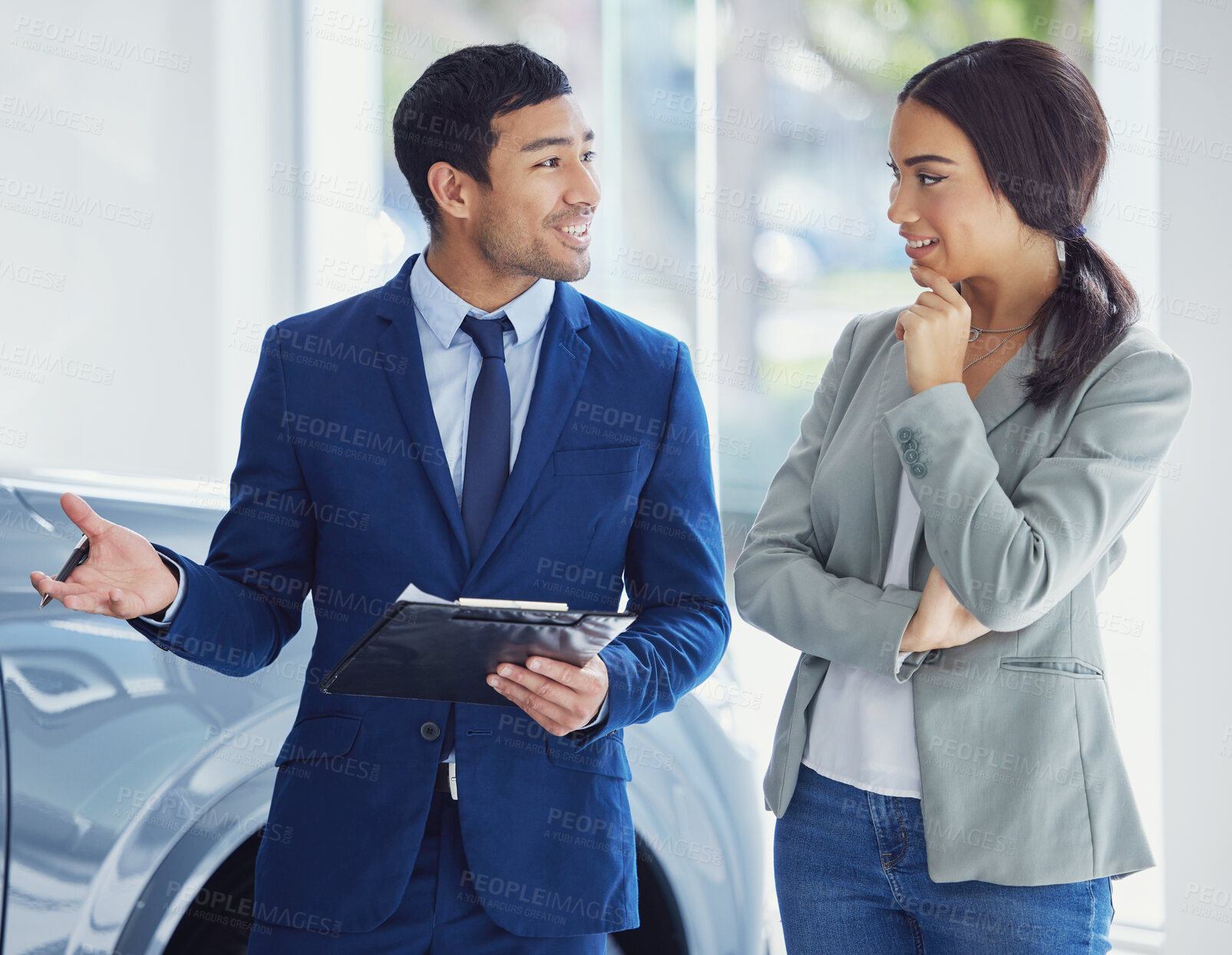 Buy stock photo People, salesman and car dealership with client, pride and confidence for transport, loan or test drive in automobile. Woman, man and excited in showroom for decision in buying new vehicle in shop
