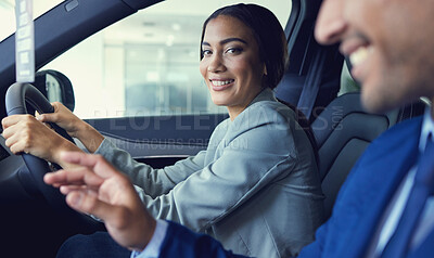 Buy stock photo Cropped portrait of an attractive young woman sitting in a new car while speaking to a handsome male car salesman about a deal