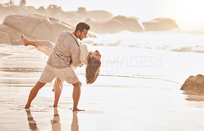 Buy stock photo Shot of a young couple dancing on the beach