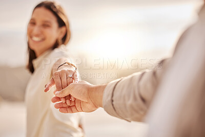 Buy stock photo Shot of a young couple showing a ring after getting engaged at the beach