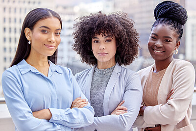 Buy stock photo Shot of a group of young businesswomen standing with their arms crossed against a city background