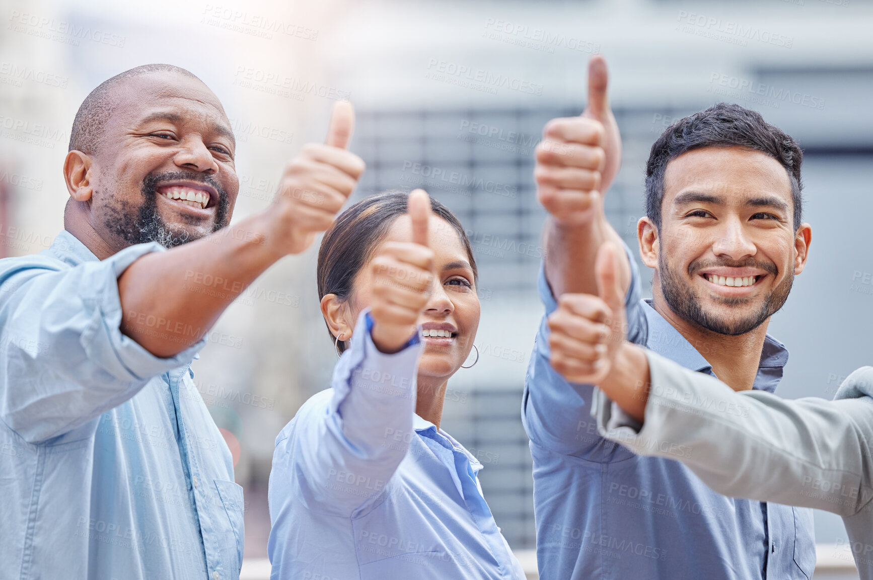 Buy stock photo Shot of a group of businesspeople showing a thumbs up against a city background