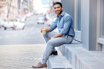 Buy stock photo Shot of a young businessman drinking a cup of coffee in the city