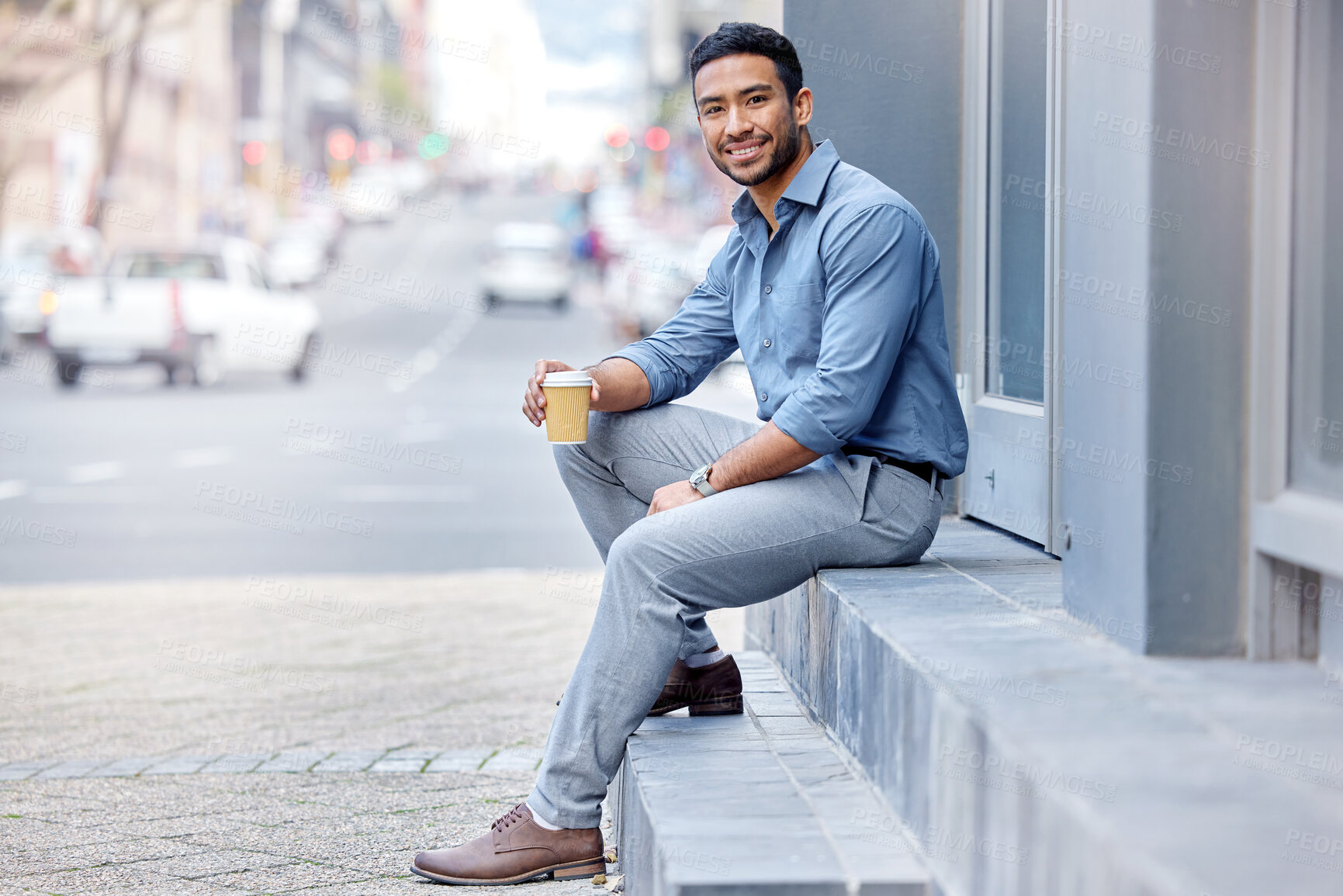 Buy stock photo Shot of a young businessman drinking a cup of coffee in the city