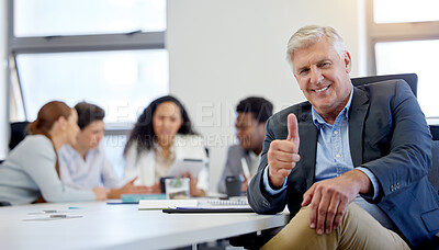 Buy stock photo Shot of a mature businessman showing a thumbs up while in a meeting at work