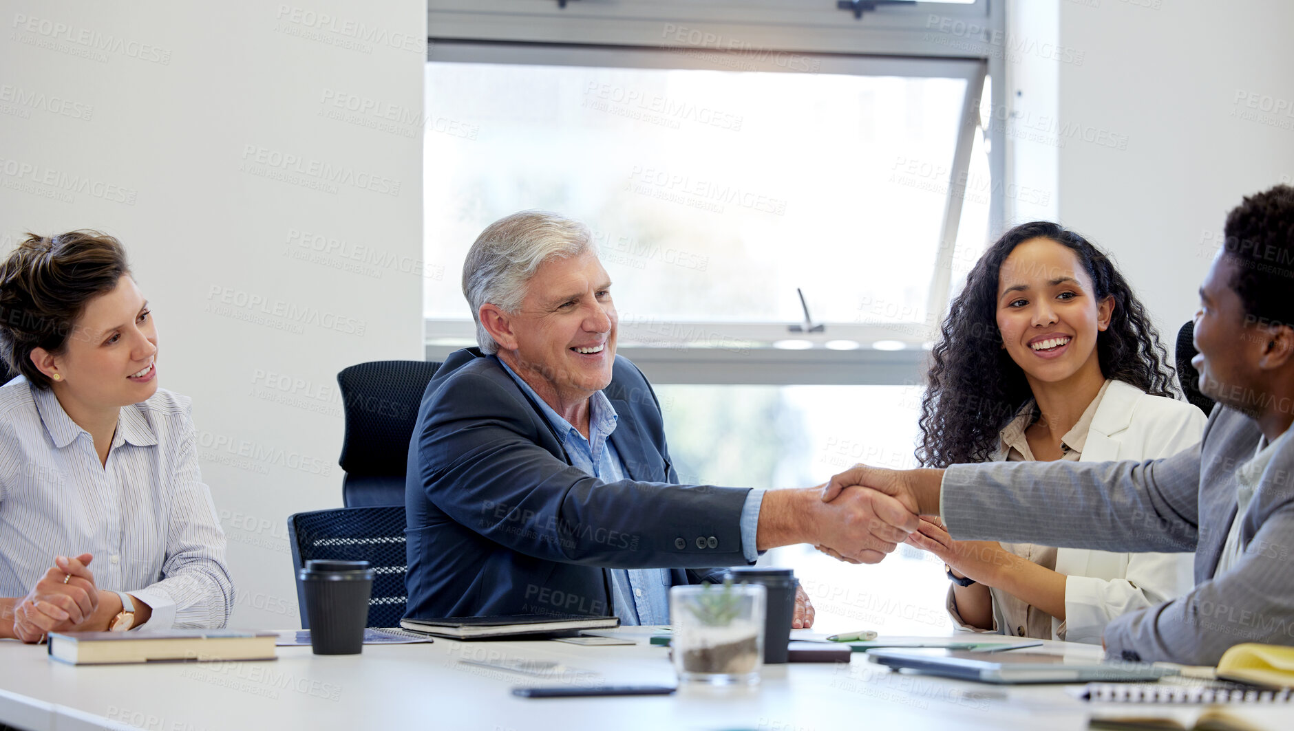 Buy stock photo Shot of two businesspeople shaking hands while in a meeting at work